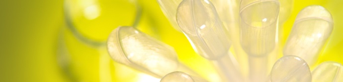 A group of clear test tubes against a yellow background.
